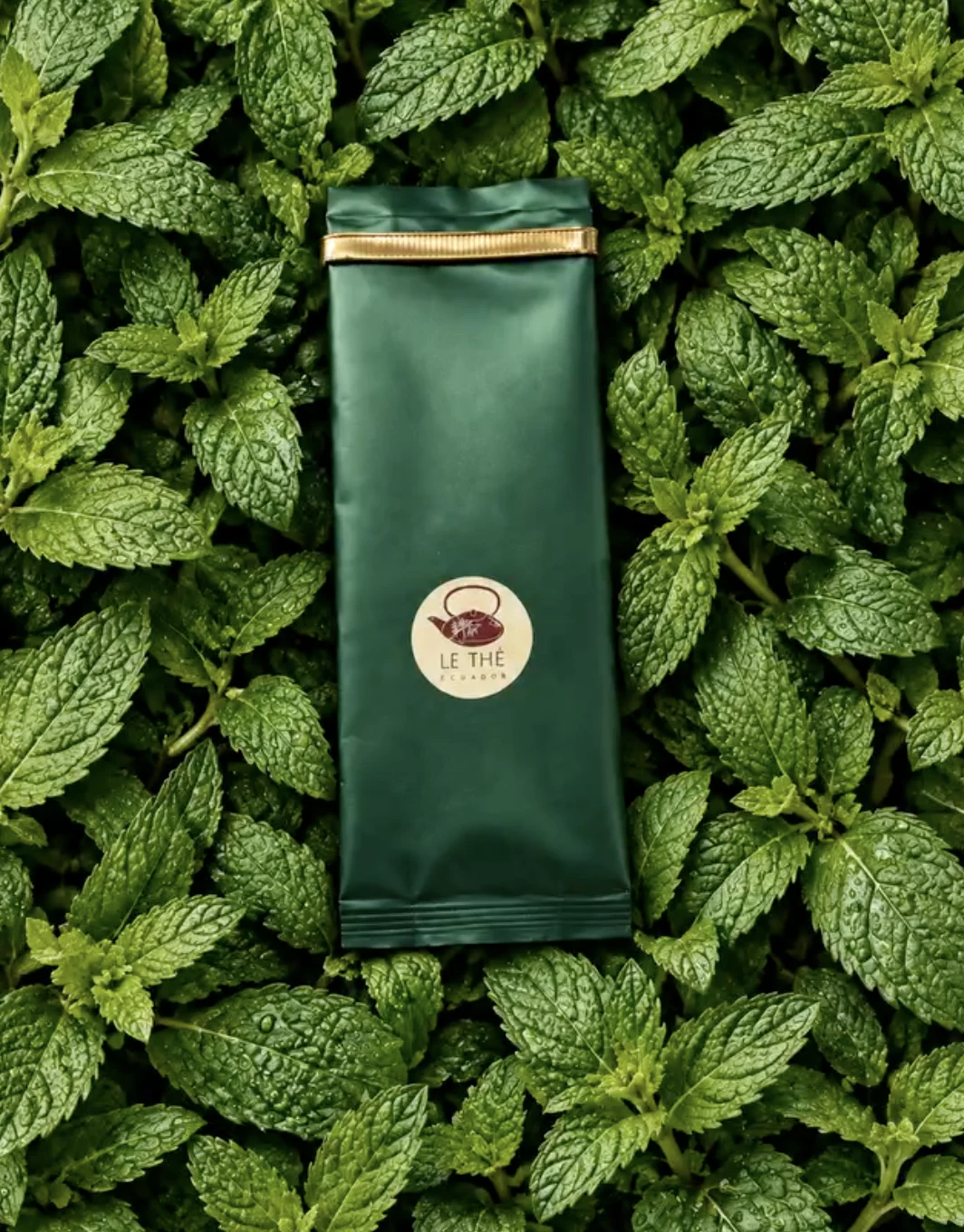 Empaque verde de Le Thé rodeado de hojas de menta